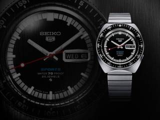 En Seiko 5 Sports-klocka med metallarmband avbildad mot en mörk bakgrund med en oskarp, större bild av en liknande urtavla.