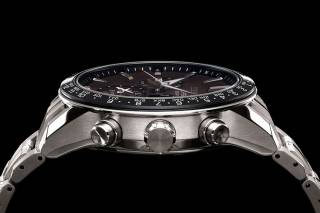 En elegant silverfärgad klocka med svart urtavla från Seiko vilar mot en svart bakgrund.