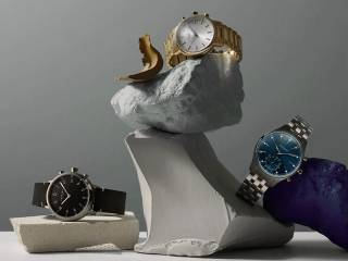 Tre Kronaby smartklockor arrangerade på konstfullt staplade grå och vita block. Klockorna inkluderar en guldklocka med vit urtavla, en svart klocka med läderarmband och en silverklocka med blå urtavla.