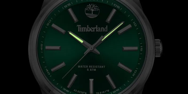 närbild på en timberland klocka med grönurtavla och självlysande visare