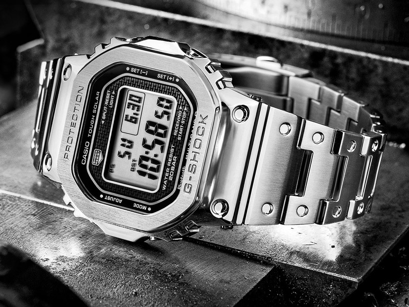 En svartvit bild med en klocka från Casio som ligger ner på en metallyta.