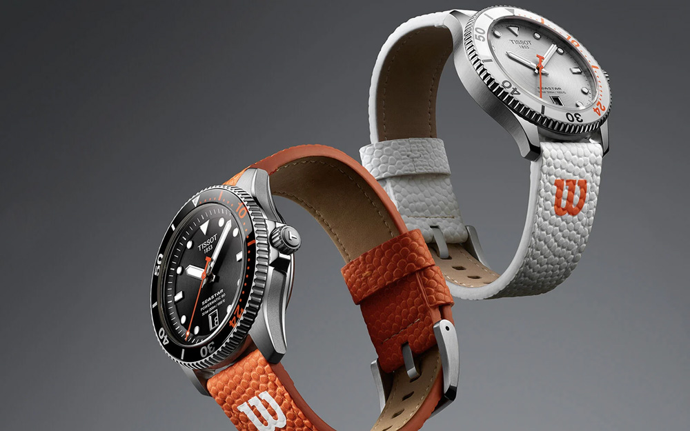Två sportiga Tissot-klockor med robust design, en med svart urtavla och orange detaljer samt orange läderband, och en med vit urtavla och vitt läderband med orange logotyp – svävande mot grå bakgrund.







