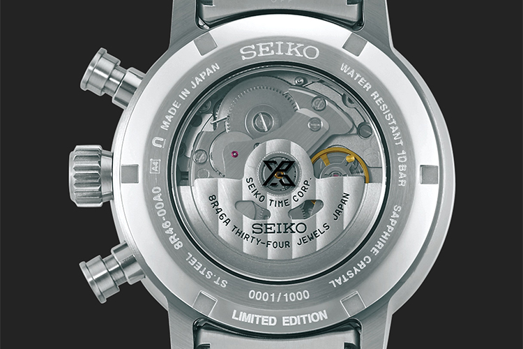 Baksidan av en silverfärgad klocka från varumärket Seiko där det mekaniska urverkets alla delar syns.