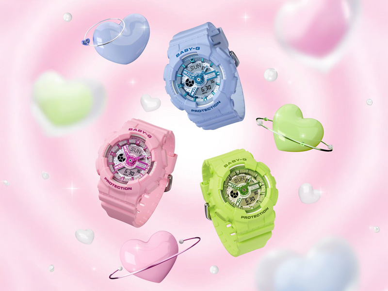 Tre Casio Baby-G barnklockor i färgerna ljusblå, rosa och neongrön flyter bland pastellfärgade hjärtan och stjärnor mot en rosa bakgrund.