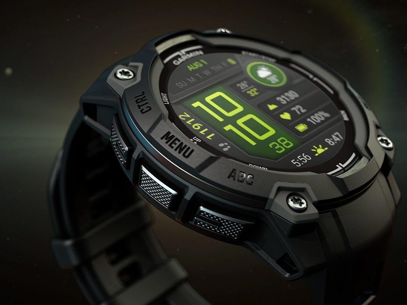 En närbild av en svart Garmin Instinct 3 sportklocka med en ljusgrön digital display som visar tid, datum, väder och träningsdata. Klockan har flera knappar runt boetten.